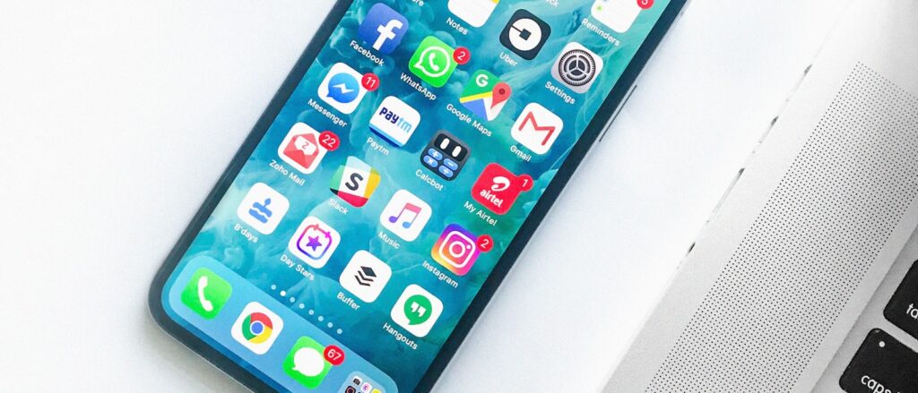 Smartphone met apps naast laptop