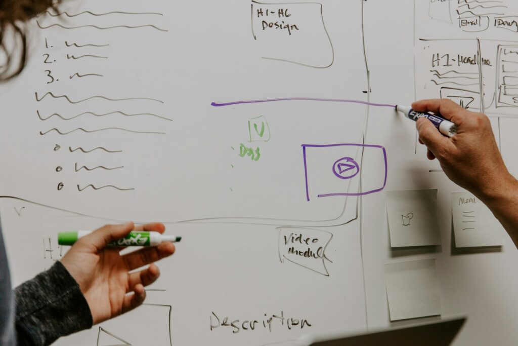 Twee mensen bij een whiteboard als beeld voor het ontwerpen van AI-agentprototypes