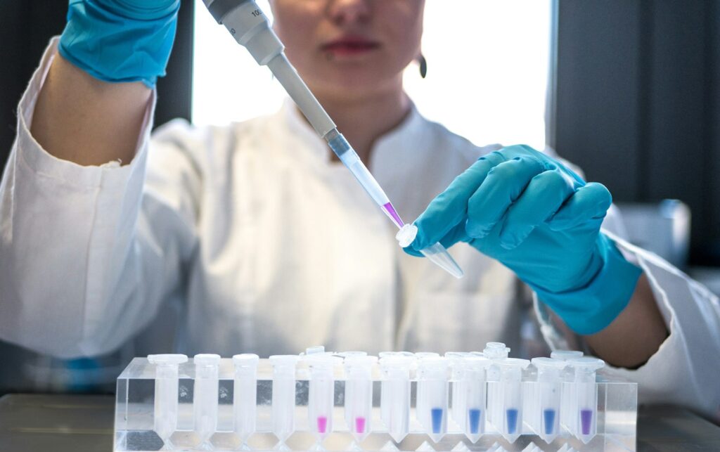 Onderzoeker met pipet en reageerbuizen als beeld voor laboratoriumdata en biotechonderzoek