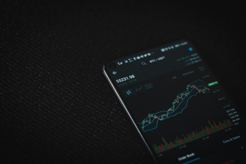 Smartphone met handelsapp als beeld voor AI-risicosignalering bij cryptotransacties