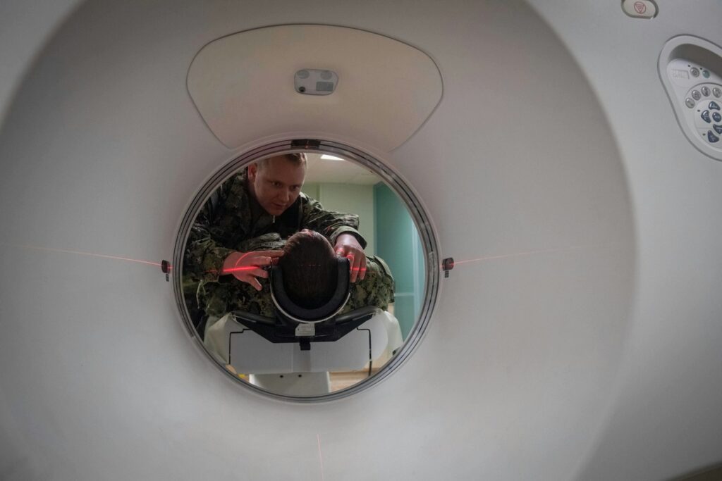 Technicus positioneert een patient bij een CT-scanner