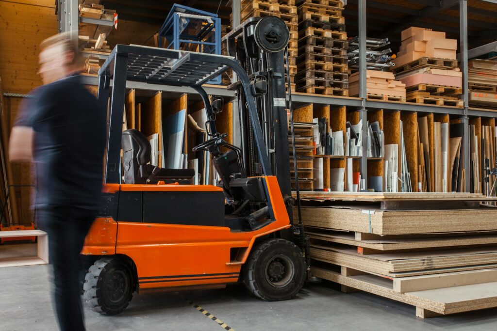 Geel met zwarte heftruck in een logistiek magazijn