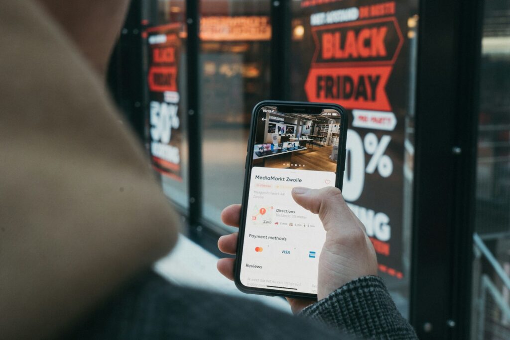 Persoon met een smartphone en een betaalkaart tijdens online winkelen