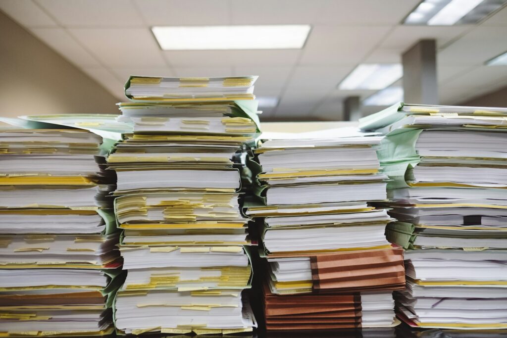 Stapels documenten en dossiermappen als beeld voor AI op overheidsdossiers