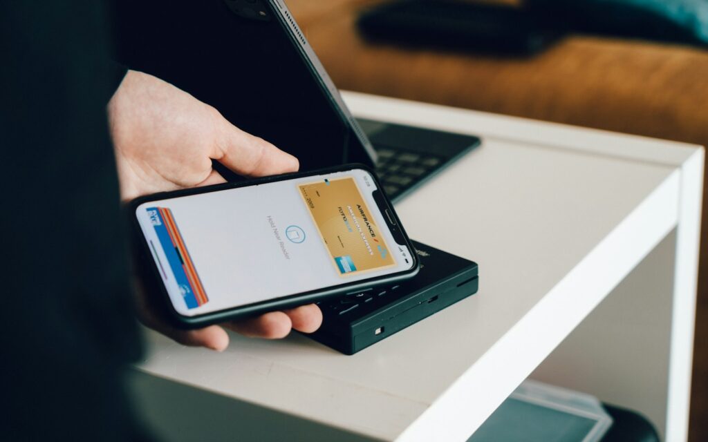 Persoon met smartphone en betaalkaart als beeld voor een digitale wallet