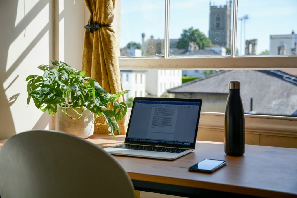 Laptop op een bruine houten tafel in een thuiswerkplek