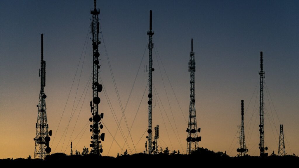 Silhouetten van telecomzendmasten tijdens zonsondergang