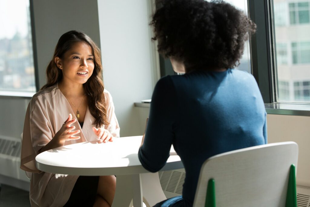 Twee mensen in gesprek aan tafel als beeld voor AI in recruitment en sollicitatiegesprekken