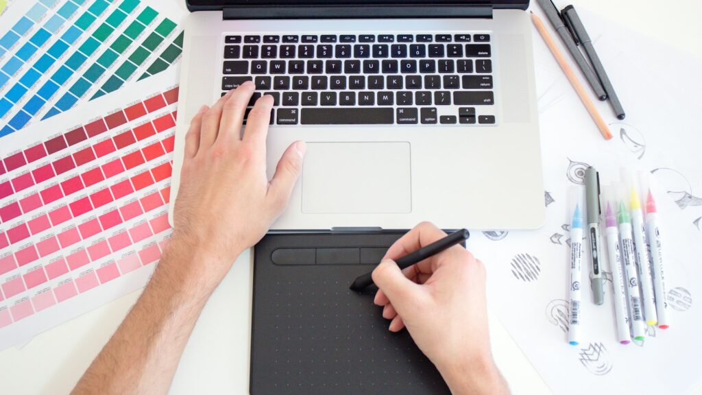 Ontwerper werkt met tablet en laptop