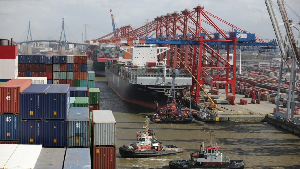 Sleepboot naast een groot containerschip