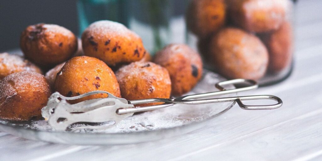 Verse oliebollen met poedersuiker op een schaal